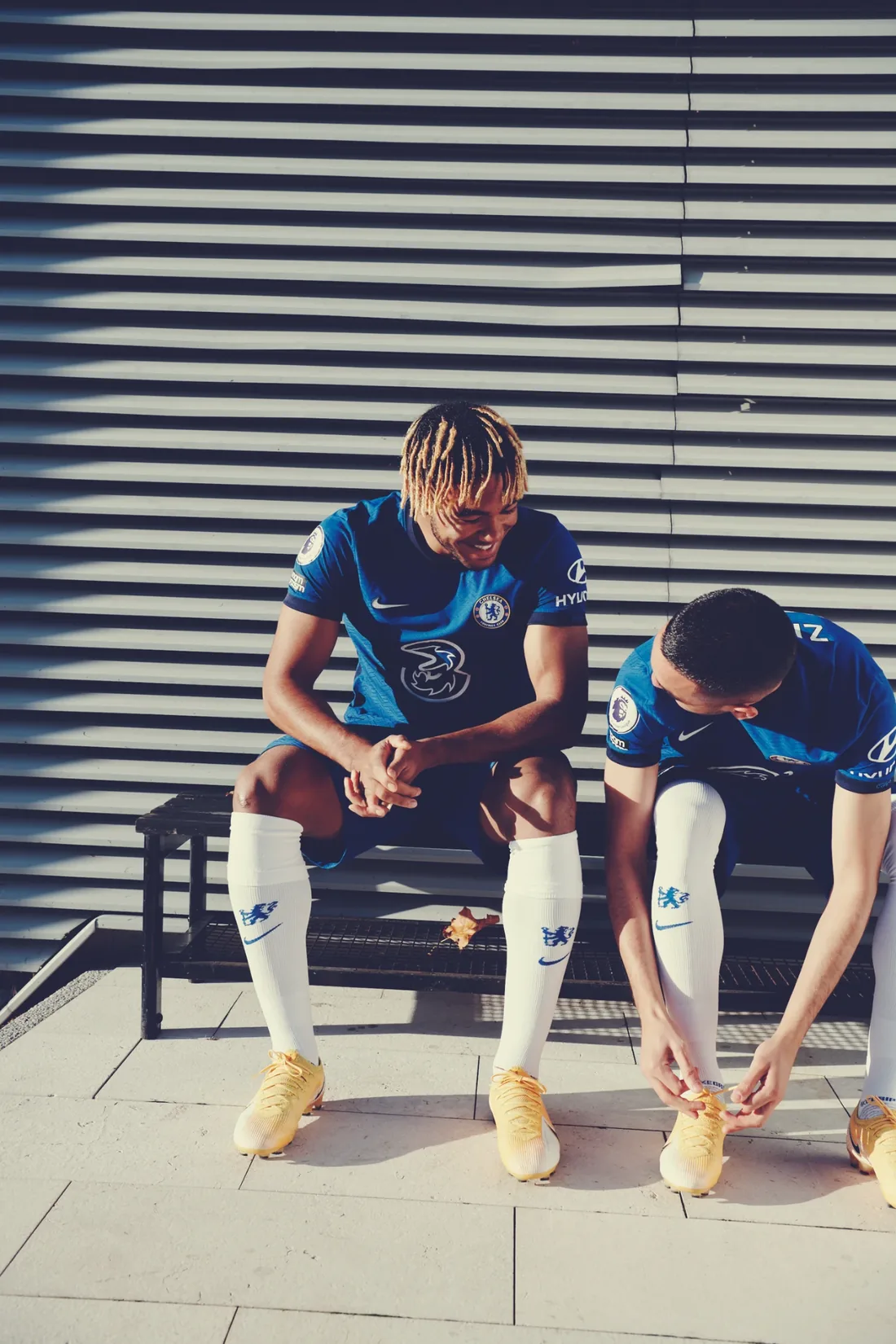 Chelsea FC: two players lacing boots on a bench